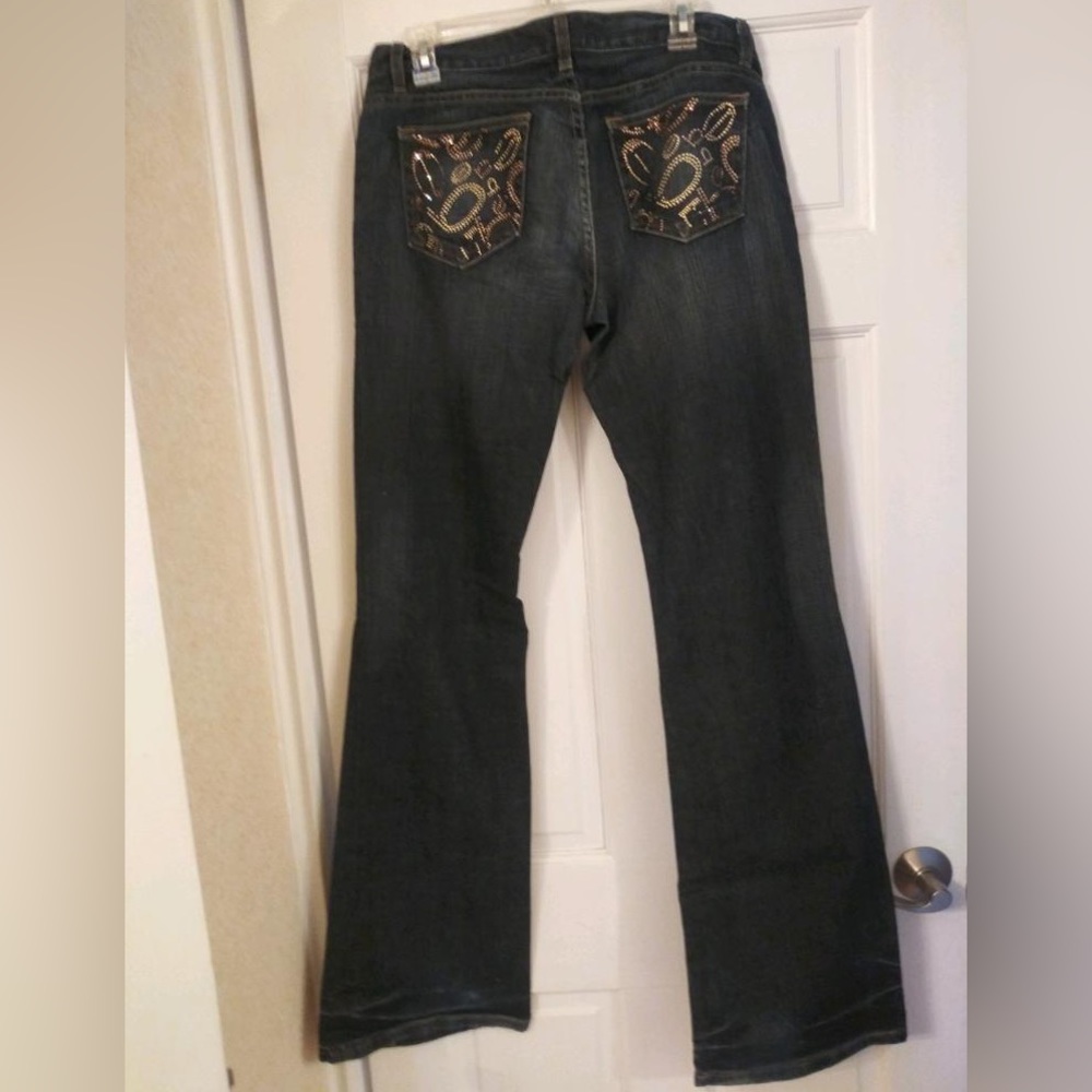 Bebe pair of jeans w/back pockets adorned with crystals. Sz 30 great condition.